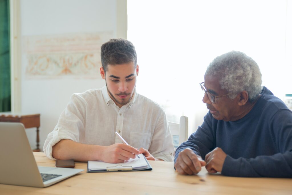 photo of man helping elderly man with medicaid appliaction